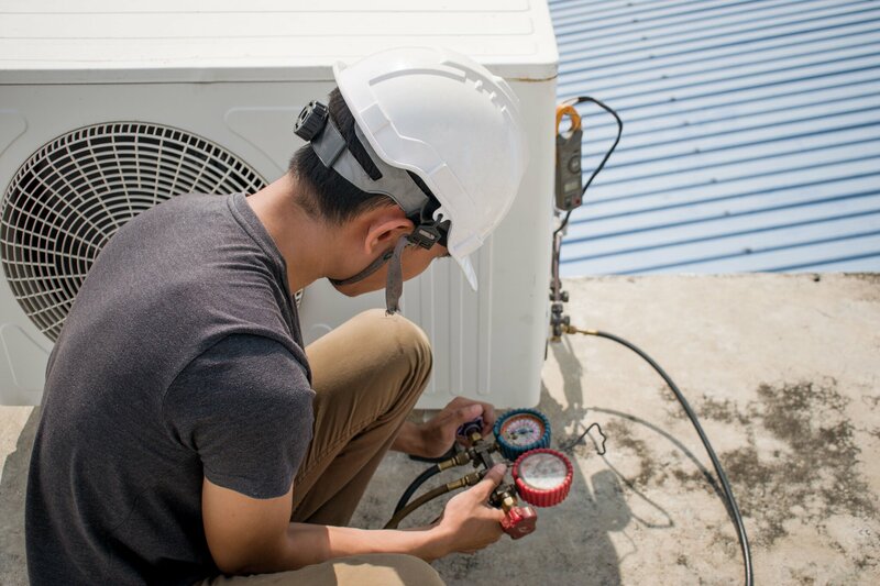 Man met helm werkt aan koelinstallatie